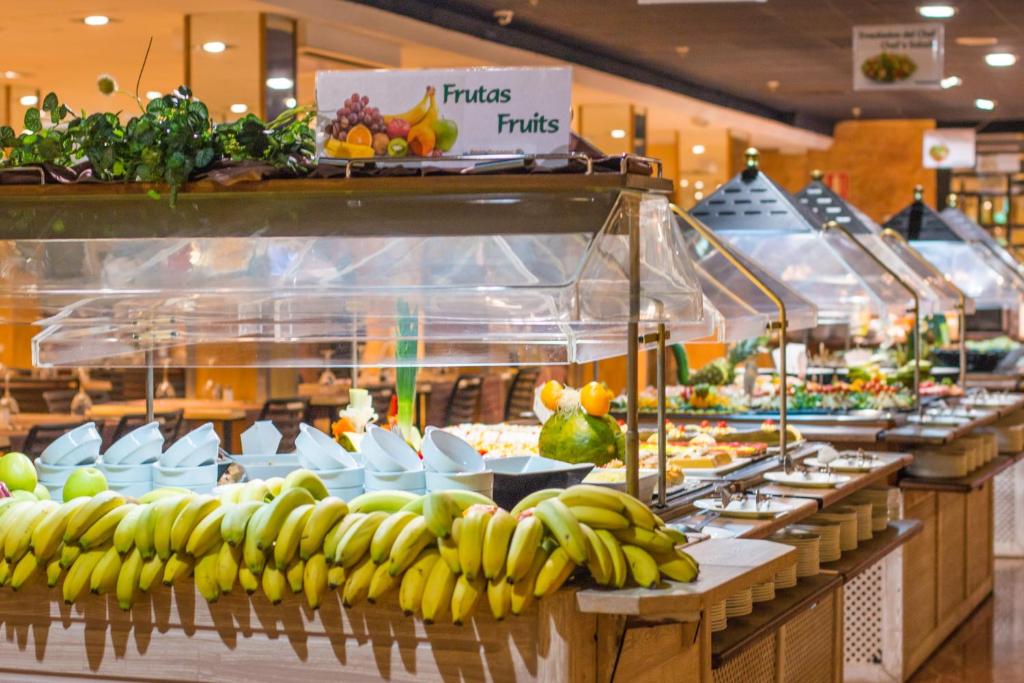 Augļu bufete ar dažādām augļu šķirnēm un dekoratīvām ēdienu prezentācijām. Iekārtota ar zaļumiem un elegantu dizainu.