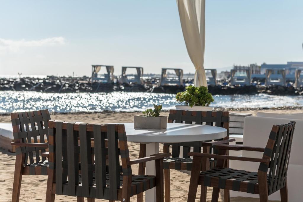 Kafejnīcas galdiņš ar krēsliem pludmalē pie Knossos Beach Bungalows Resort