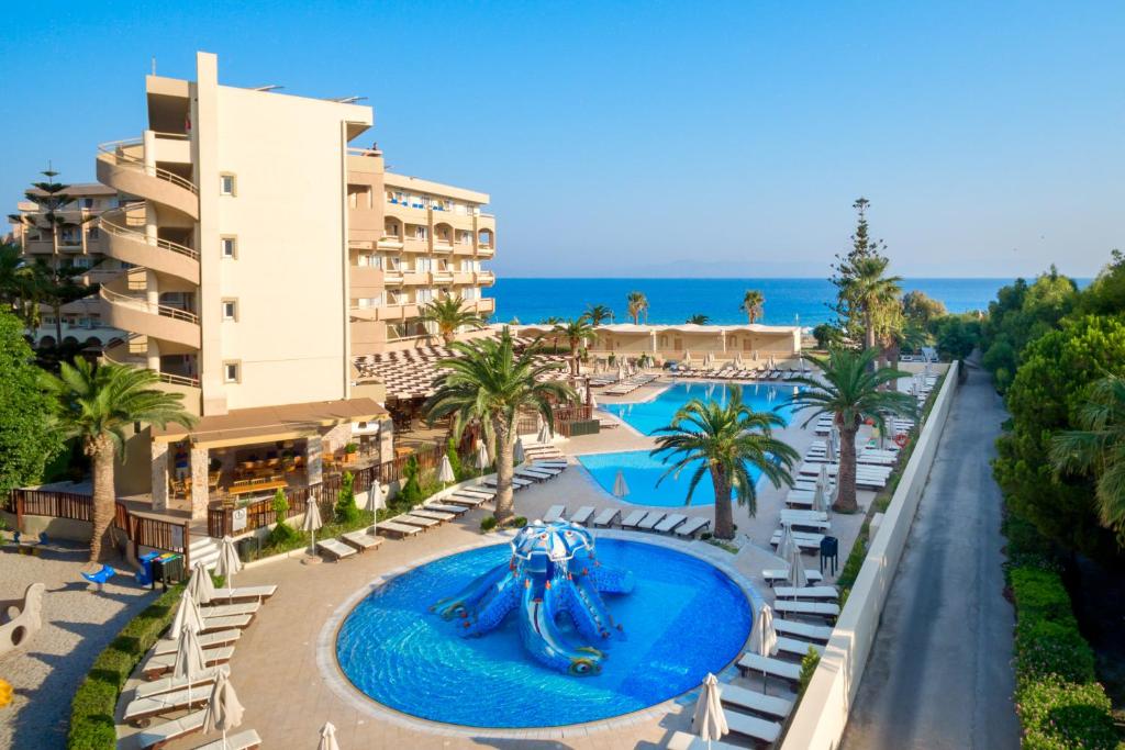Sun Beach Resort viesnīca ar baseinu un piekrasti, palmām apkārt.