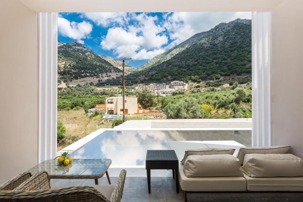 Mūsdienīgs interjers ar skatu uz kalniem un baseinu, kas aicina uz relaksāciju un dabas baudīšanu. Gaismas un telpas sajūta radīta, izmantojot plašos logus.