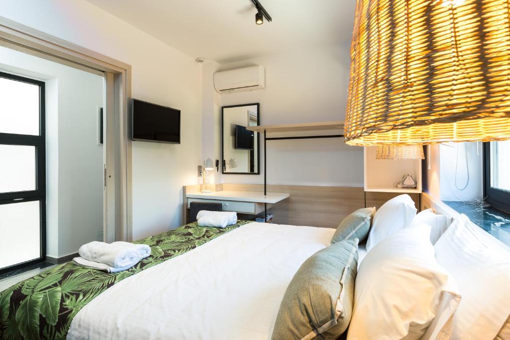 Mūsdienīga viesnīcas numura iekārtojums ar lielu gultu, palmām izrotātu gultas veļu un stilīgu apgaismojumu. Telpā ir televizors un rakstāmgalds.