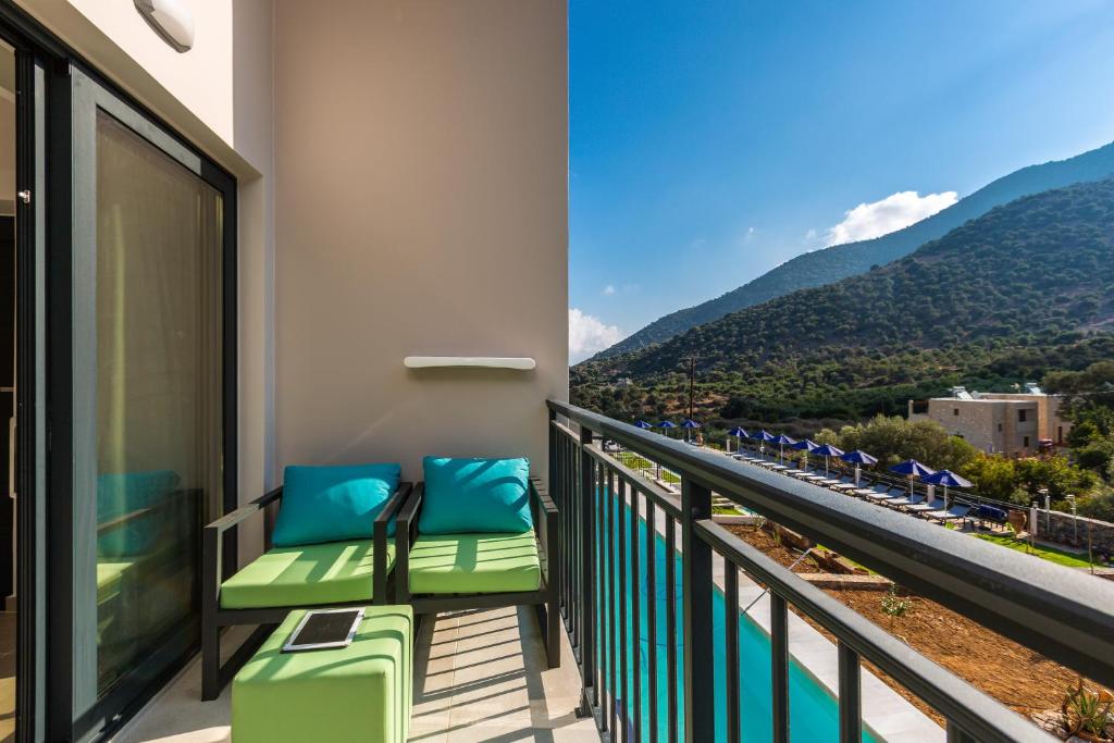 Balkons ar zaļiem krēsliem un zilu spilvenu, skats uz kalniem un baseinu. Ideāla vieta relaksācijai un atpūtai.