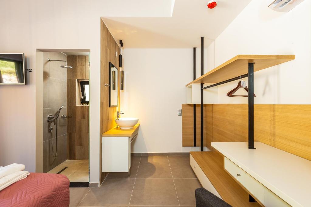 Mūsdienīga viesnīcas numura iekārtojums ar dušu, izlietni un plašu uzglabāšanas vietu. Numurā ir televizors un ērta atpūtas zona.