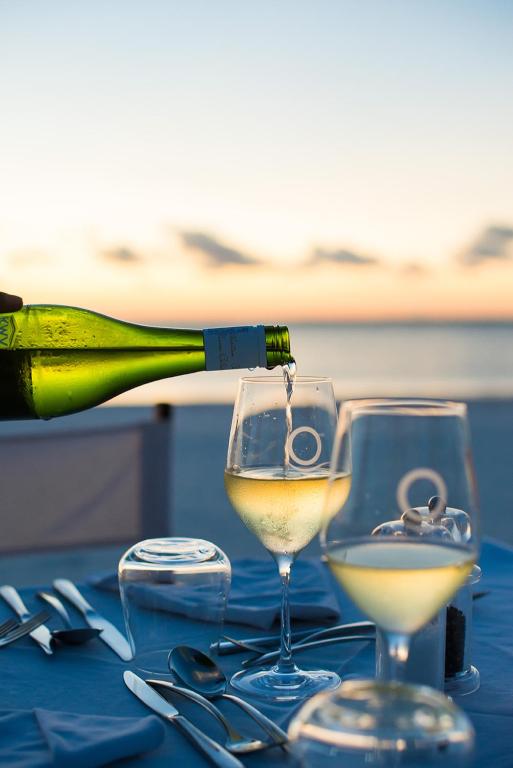 Vīna glāzes pie jūras saulrietā, Konokono Beach Resort