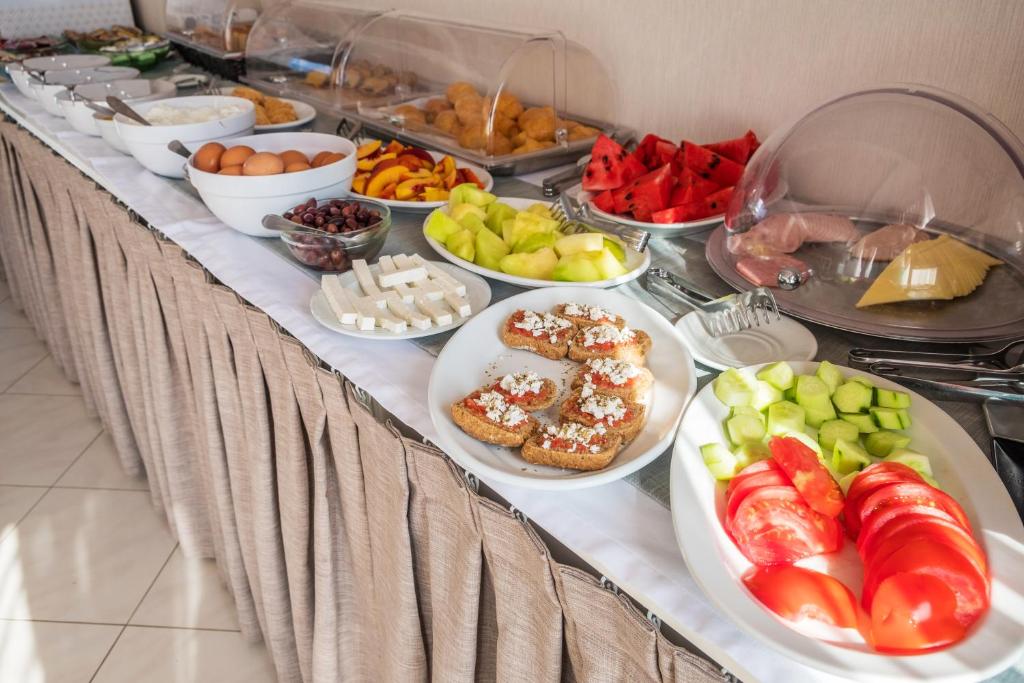 Bagātīgs brokastu bufetes galds ar dažādiem ēdieniem, tostarp augļiem, dārzeņiem, maizi un olām. Ideāls izvēles klāsts veselīgām brokastīm.
