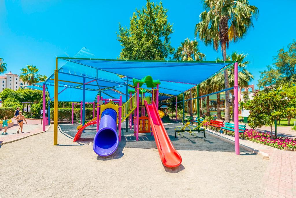 Krāsains bērnu rotaļu laukums ar slīdkalniņiem un nojumi, apzaļumots ar palmām un ziediem. Ideāla vieta bērnu izklaidei un atpūtai.