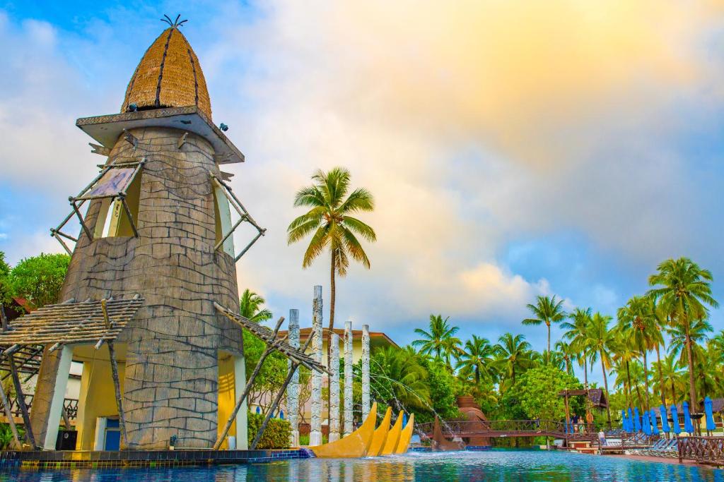Graceland Khaolak Resort & Spa peldbaseins ar unikālu arhitektūru un palmu kokiem