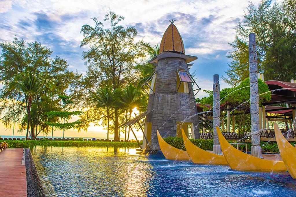 Graceland Khaolak Resort & Spa baseins ar saulrietu un eksotiskām palmām.