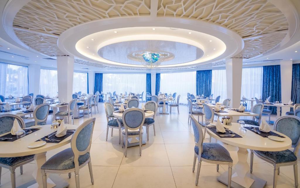 Adams Beach restorāns ar elegantu interjeru un zilām krēsliem.