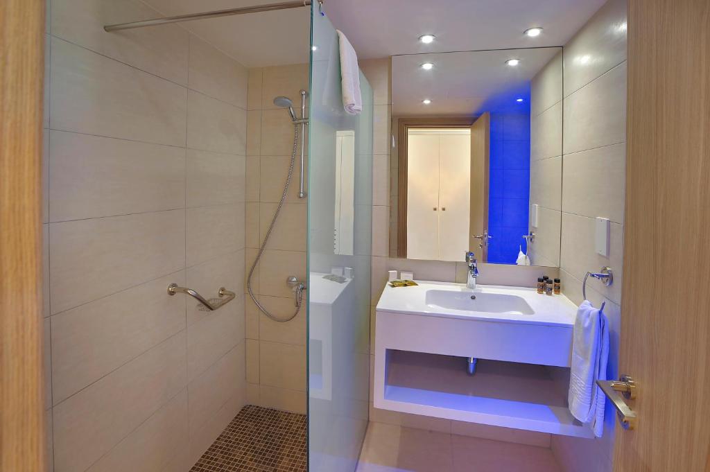 Mūsdienīgs vannas istabas interjers ar dušu, izsmalcinātu izlietni un modernām apgaismojuma iespējām. Elegants dizains ar neitrālām krāsām un uzglabāšanas risinājumiem.