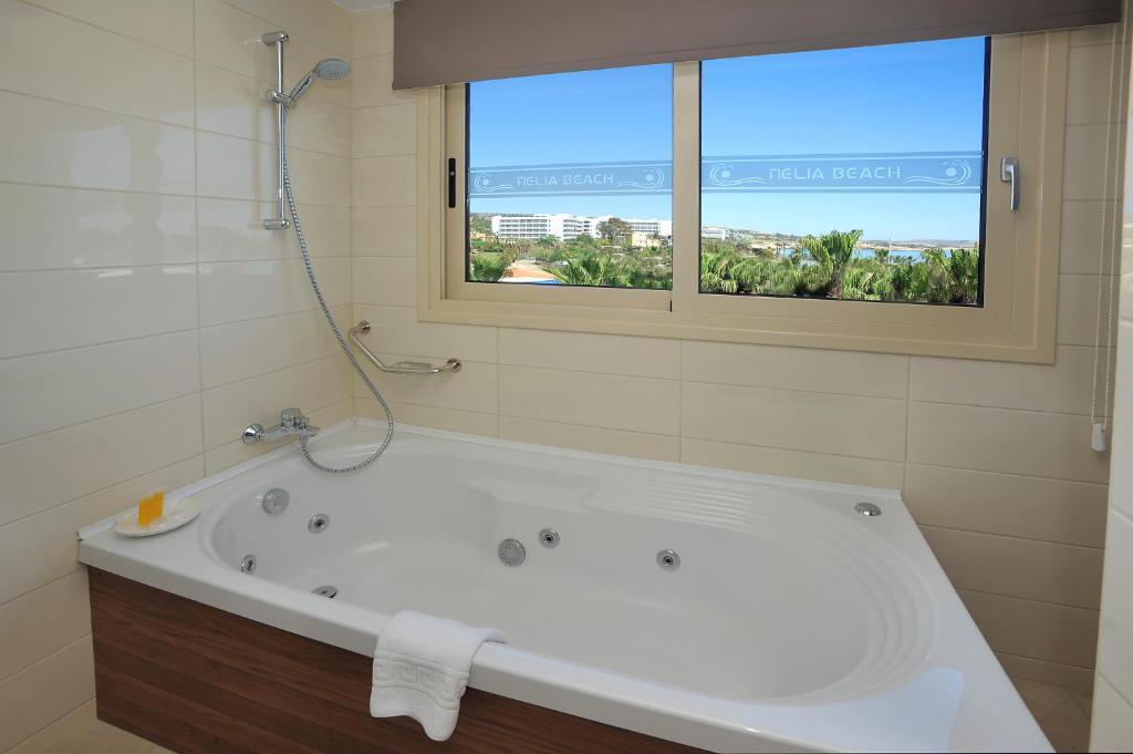 Mūsdienīga vanna ar skatu uz dabu, kas nodrošina relaksējošu atmosfēru. Telpa ir gaiša un eleganta, radot komfortu un mieru.