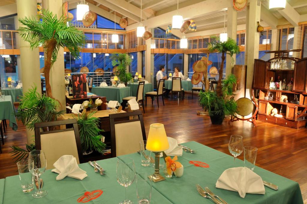 Susesi Luxury Resort restorāns ar elegantiem galdiem un dabīgu apgaismojumu
