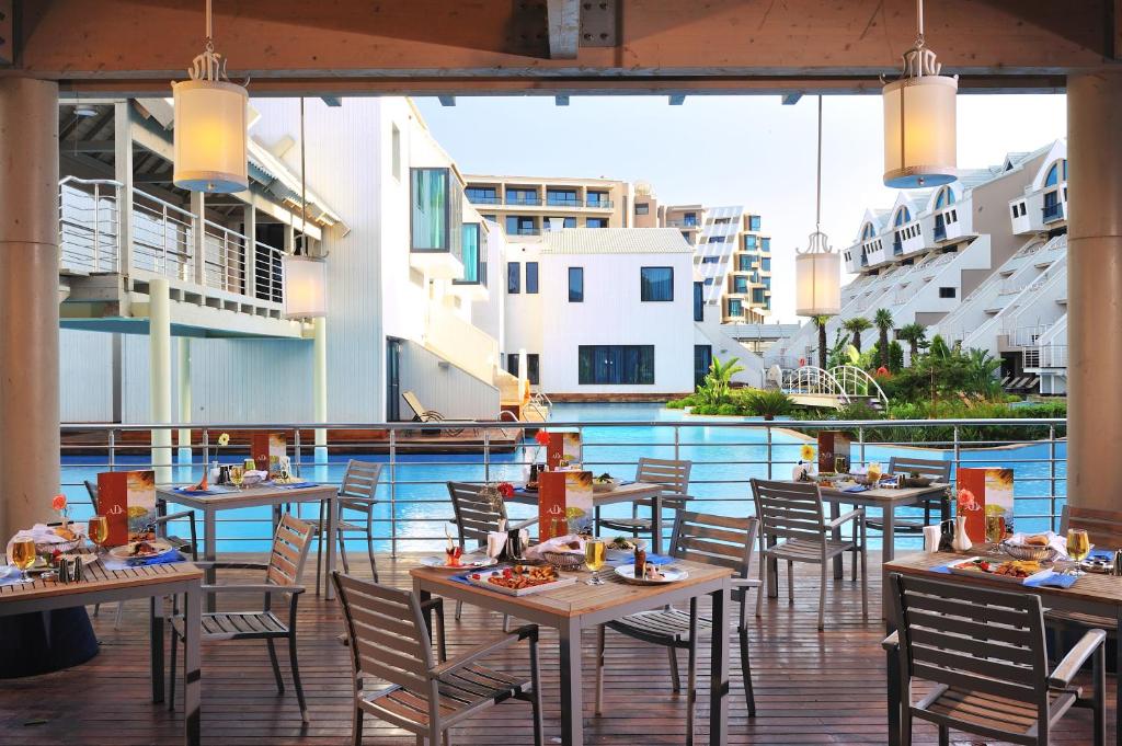Susesi Luxury Resort terase ar skatu uz baseinu un svētku galdiem