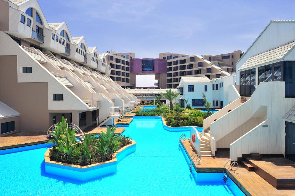 Susesi Luxury Resort baseins ar modernām ēkām un zaļumiem