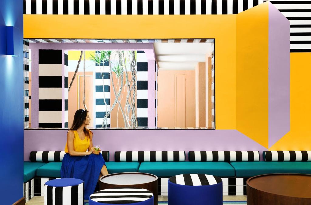 SALT of Palmar modernais interjers ar krāsainām sienām un komfortablu sēdvietu.