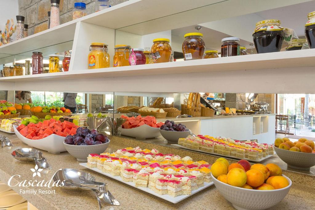 Krāsains brokastu bufete ar augļiem, saldajiem ēdieniem un ievārījumiem, kas sakārtoti uz plauktiem un galda. Ideāla vieta ģimenes atpūtai un gardēžu baudīšanai.