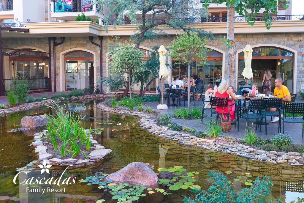 Relaksējoša atmosfēra pie Cascadas Family Resort, kur viesi izbauda maltītes dārzā blakus dīķim ar zaļumiem un akmeņiem. Ideāls galamērķis ģimenēm un draugiem.