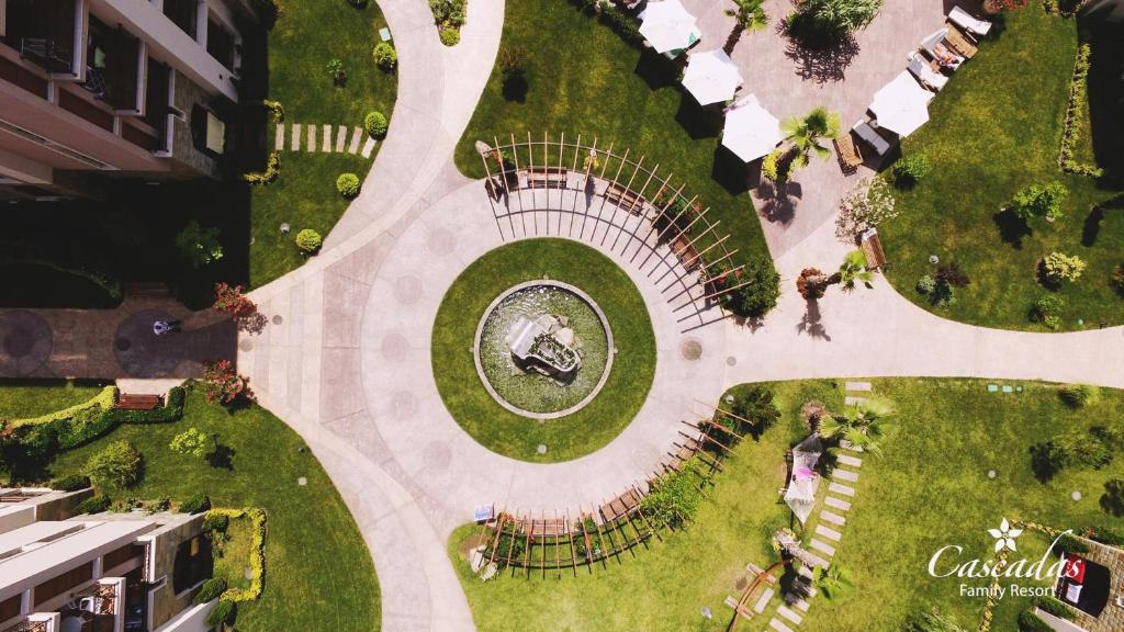 Zaļš atpūtas dārzs ar centrālo strūklaku un pastaigu celiņiem, apkārt esošajiem saulessargiem un ērtām atpūtas vietām. Ideāla vieta ģimenes brīvā laika pavadīšanai.