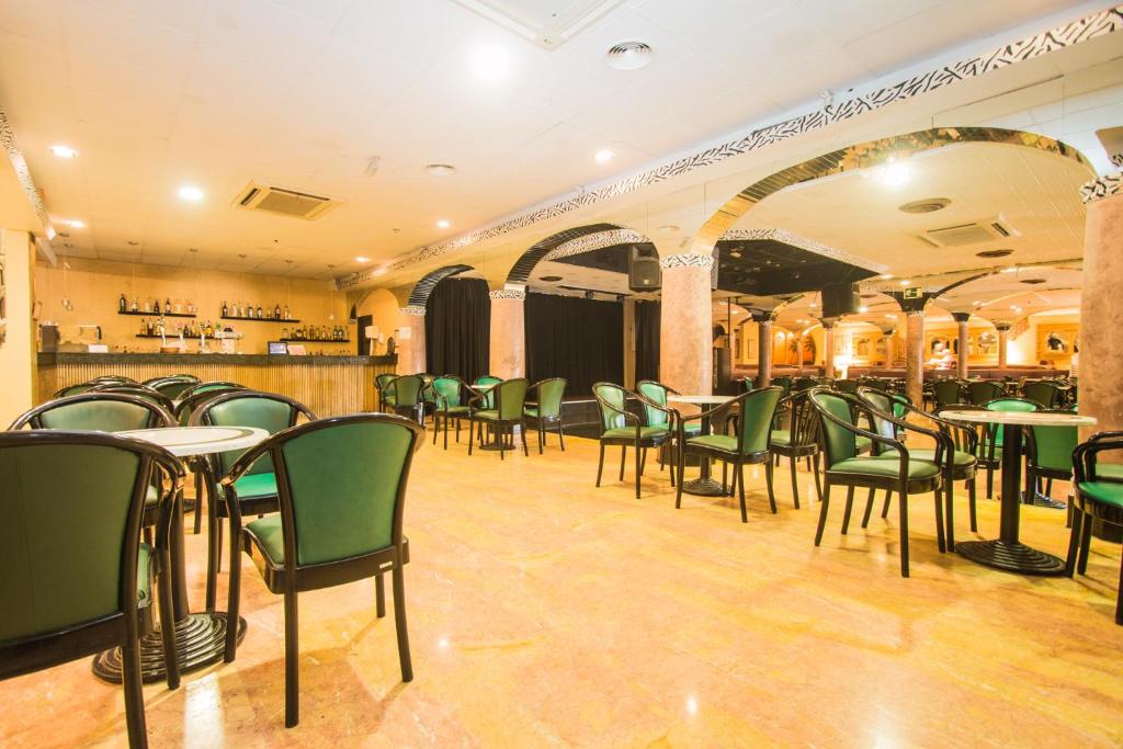 Bāra interjers ar zaļām krēslām un galdiem, pie bāra letes ir daudzi dzērieni, kas gaida apmeklētājus. Telpa ir plaša un gaiša, ar siltu atmosfēru.