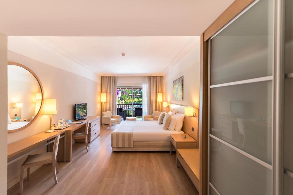 Mūsdienīgs numurs viesnīcā Turquoise Hotel ar balkonu un dārza skatu.