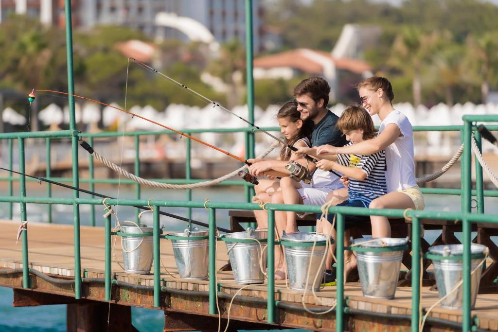 Ģimene zvejo no piestātnes pie Turquoise Hotel