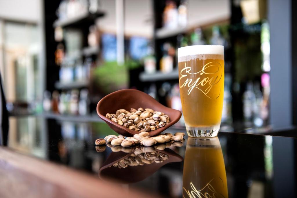 Alus glāze ar uzrakstu 'Enjoy' un rieksti Turquoise Hotel bārā.