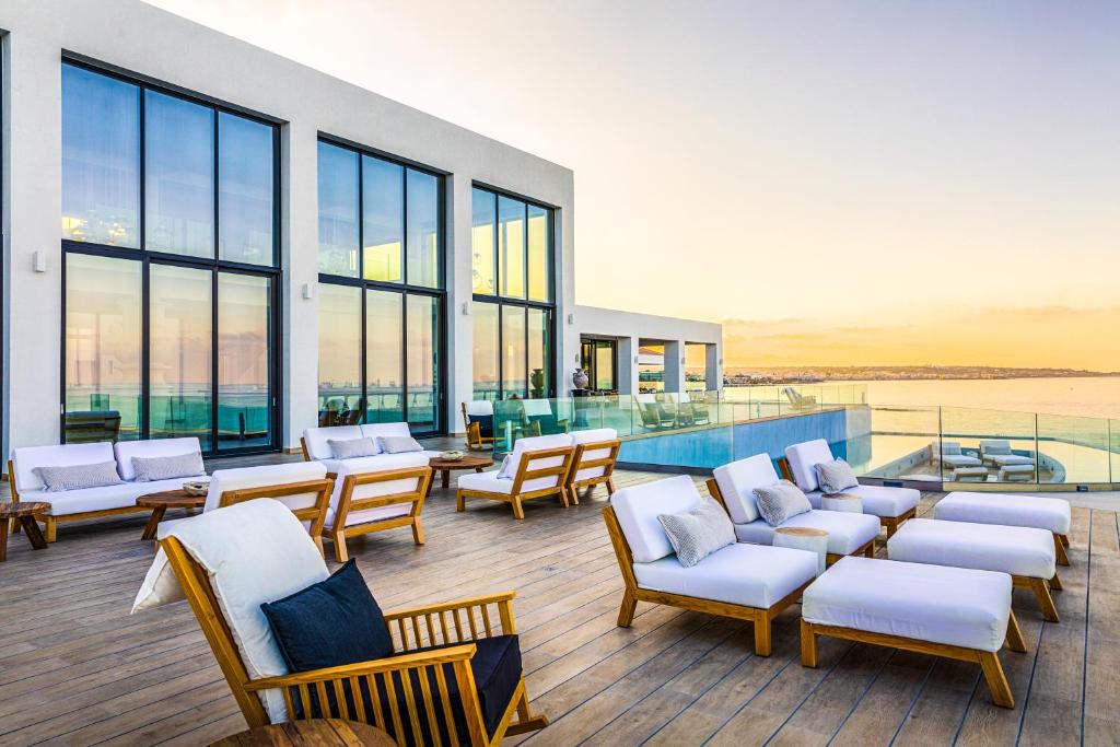 Abaton Island Resort & Spa terase ar skatu uz jūru un komfortablām mēbelēm