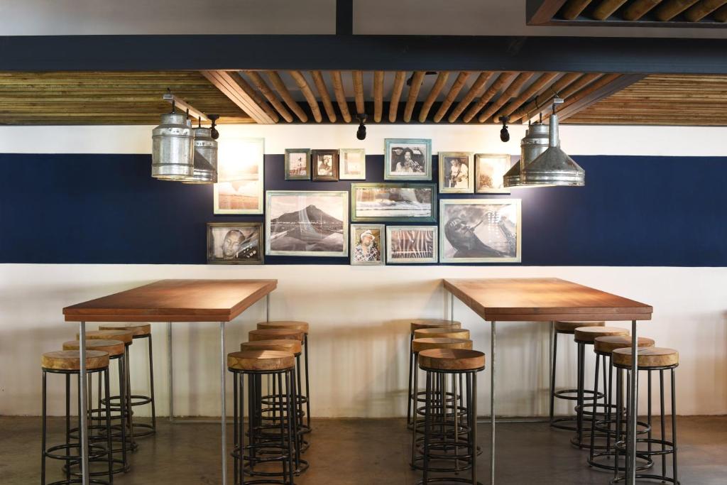 Mūsdienīgs bārs ar koka galdiem un apgaismojumu Veranda Tamarin Hotel & Spa.