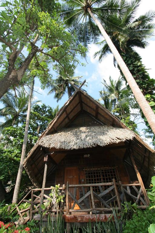 Tropu mājiņa pie Banpu Koh Chang, ieskauta palmās un zaļumos.