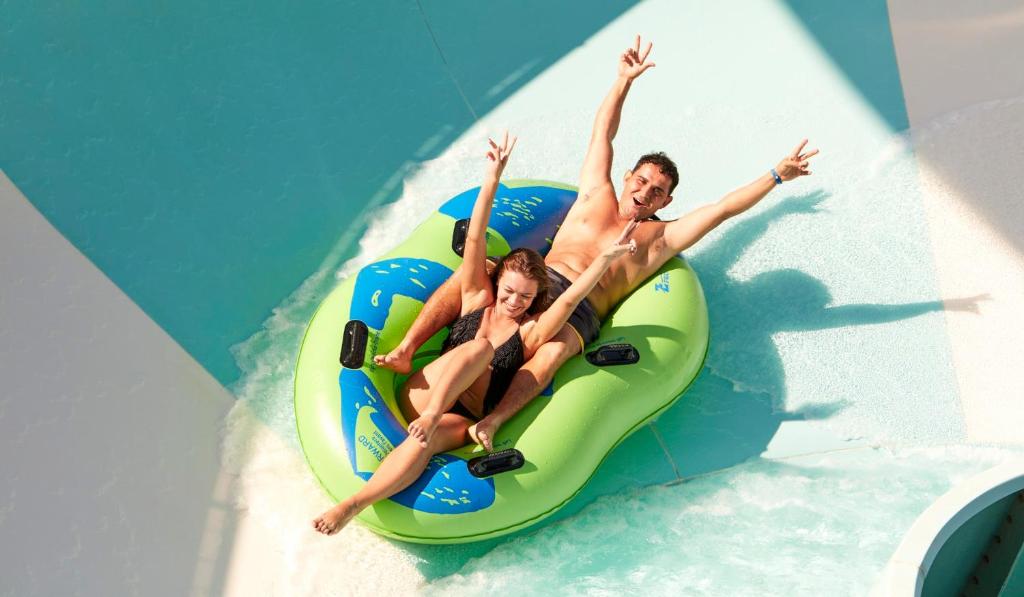 Jauni pāri izbauda ūdens atrakcijas Coral Sea Holiday Village Resort.