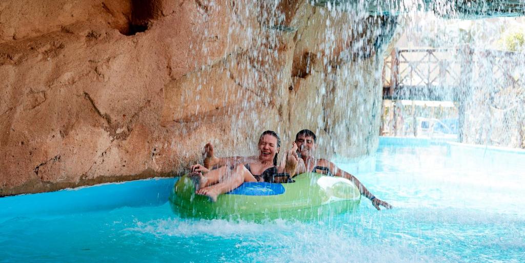 Divi apmeklētāji izbauda atpūtu uz pludiņa Coral Sea Holiday Village Resort ūdens parkā.