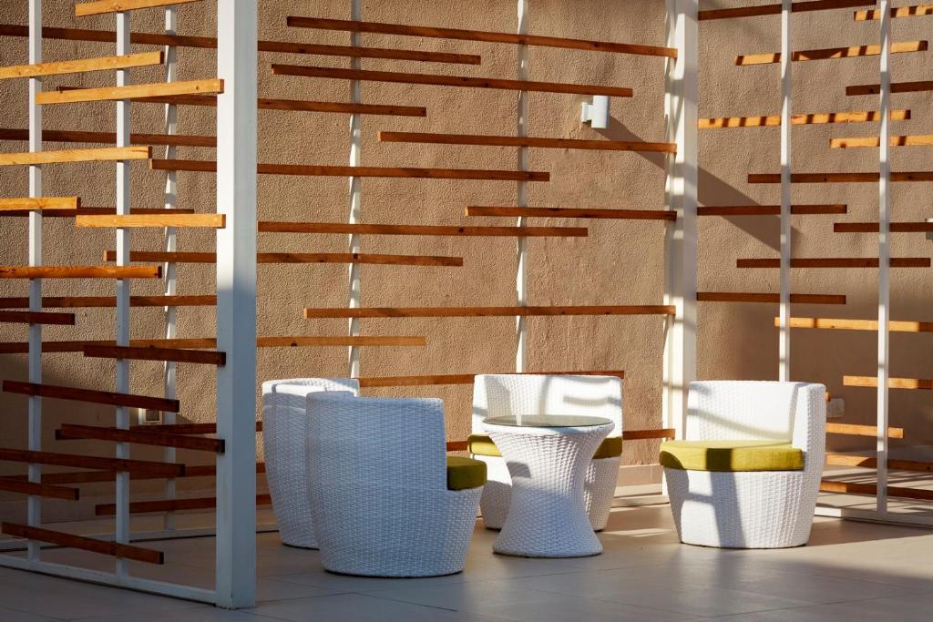 Moderns sēžamais stūris Coral Sea Holiday Village Resort ar baltiem krēsliem un dzeltenām pārvalkiem.