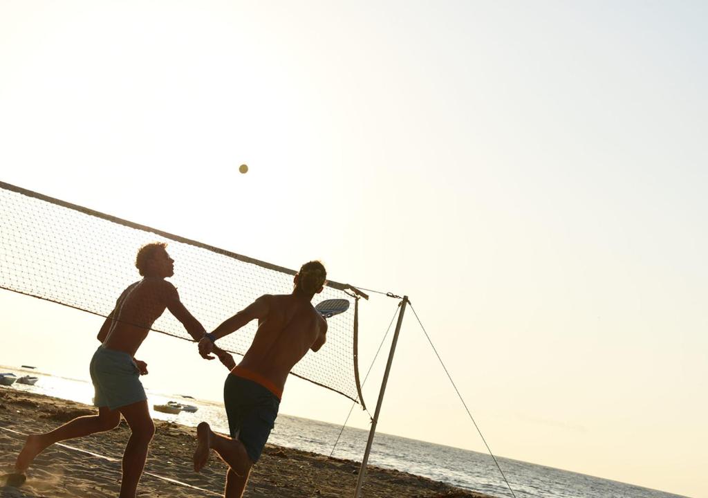 Divi vīrieši spēlē pludmales tenisu pie Veranda Tamarin Hotel & Spa