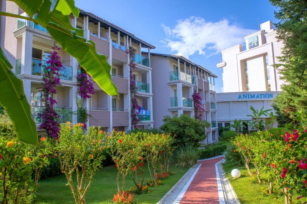 Sealife Buket Resort & Beach viesnīcas dārzs ar ziedošiem krūmiem un ēkām