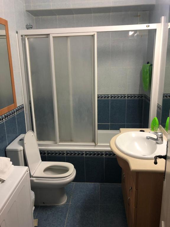 Mūsdienīgs vannas istabas interjers ar dušas kabīni, tualeti un izlietni. Telpa ir izdekorēta ar gaišām flīzēm un funkcionāliem mēbeļiem.