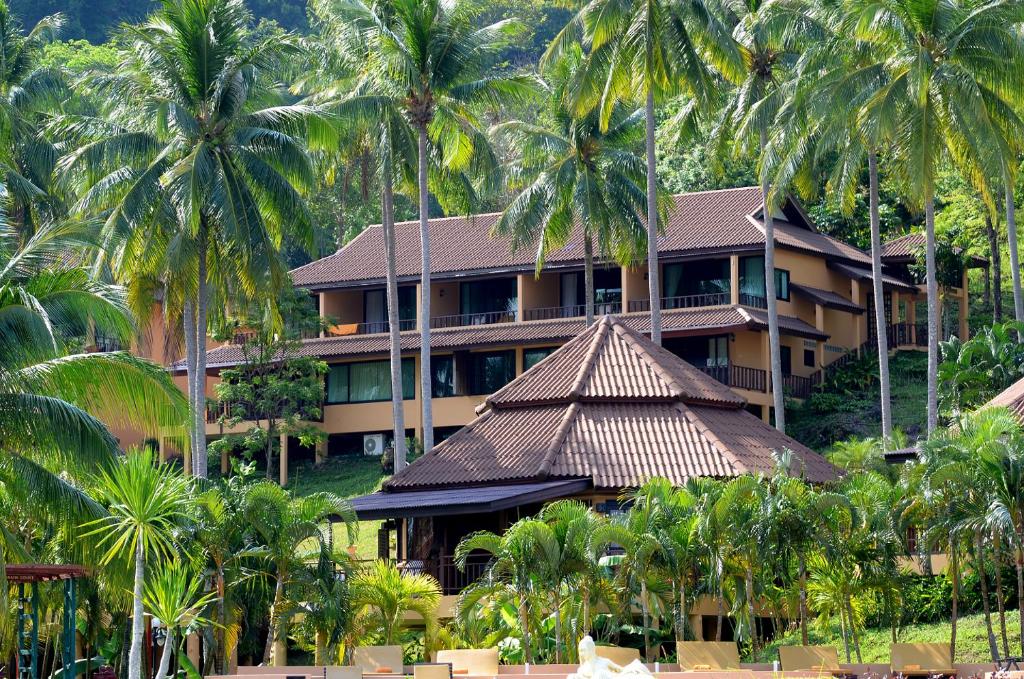 Aiyapura Koh Chang Resort ēkas piekrastē ar palmām apkārt.