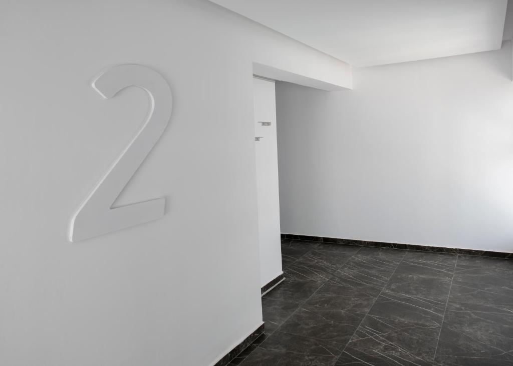 Balds ar baltu sienu un lielu numuru "2", kas izceļas, un melnu akmens grīdu.