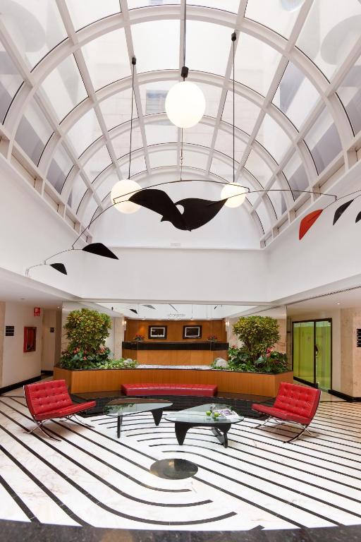 Mūsdienīgā viesnīcas vestibilā ir eleganti sarkanie krēsli un stilīgs apgaismojums, ko papildina melno un sarkano mākslas elementu karājas. Interjers izceļas ar ģeometrisku grīdu un zaļiem augiem.