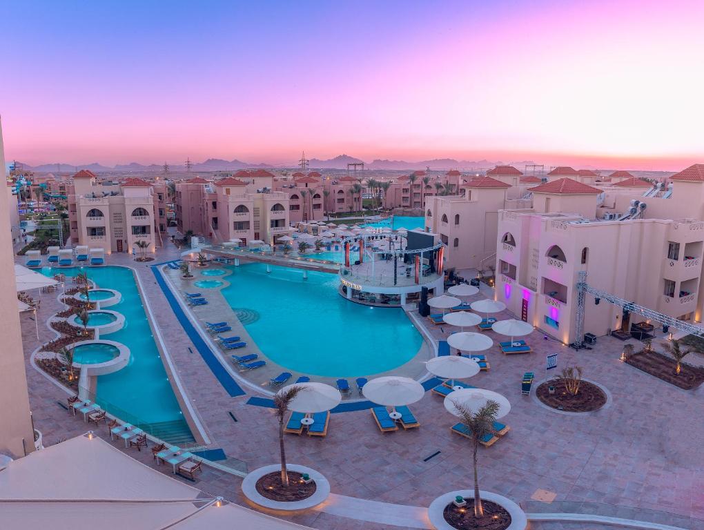 Albatros Aqua Blu Resort baseins un apkārtne pie saulrieta.