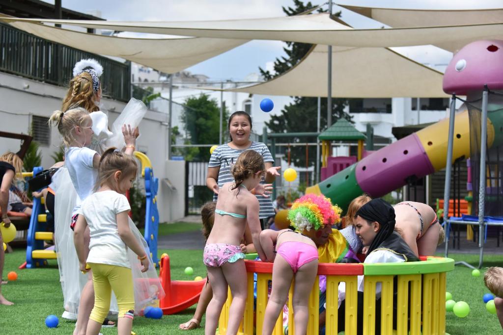 Bērni rotaļājas un izbauda spēles Parkım Ayaz Hotel bērnu laukumā.
