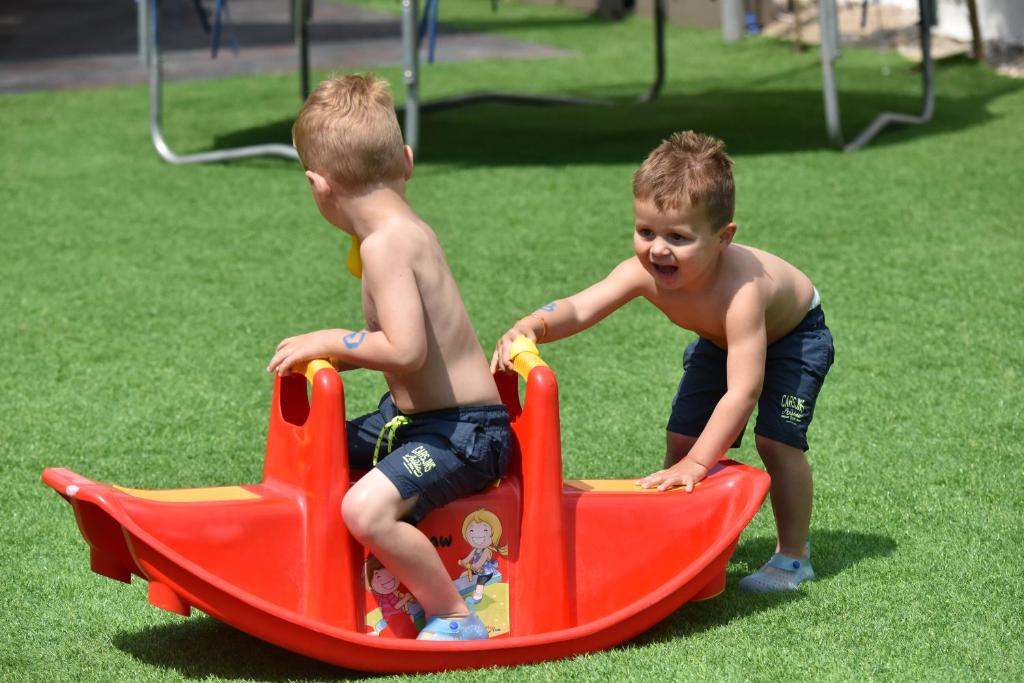 Bērni spēlējas pie Parkım Ayaz Hotel rotaļu laukumā uz šūpuļkrēsla.