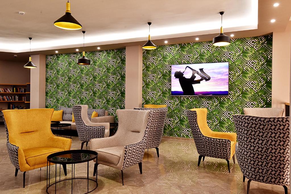 Mūsdienīgs atpūtas stūris Parkım Ayaz Hotel ar stilīgām krēslām un televīzoru.