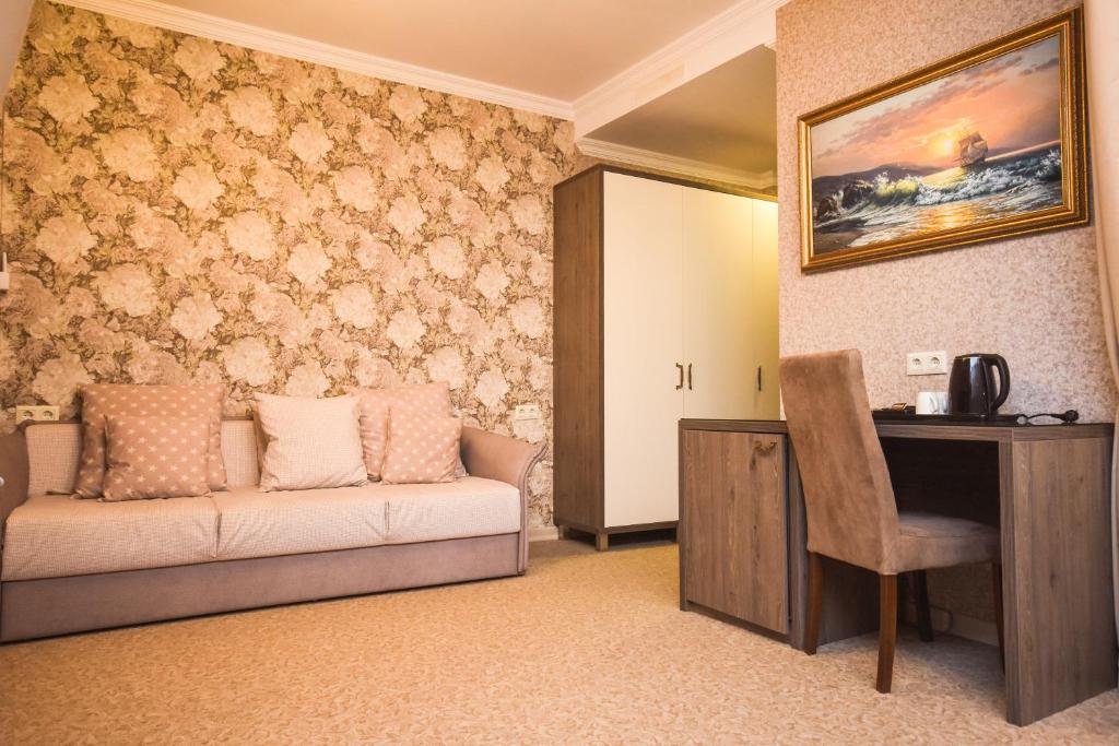 Mūsdienīgs viesnīcas numurs ar romantisku tapeti, ērtu dīvānu un darba galdu, kas aprīkots ar tējkannu un krūzēm. Numurs piedāvā mājīgu atmosfēru un praktiskas mēbeles.