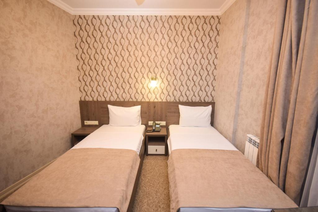 Divvietīgs numurs ar divām atsevišķām gultām un mūsdienīgu interjeru. Sienas rotā eleganta rakstu tapete, radot komfortablu atmosfēru.