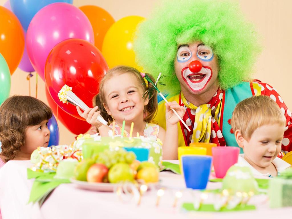 Bērni svin dzimšanas dienu ar klaunu un krāsainiem baloniem.