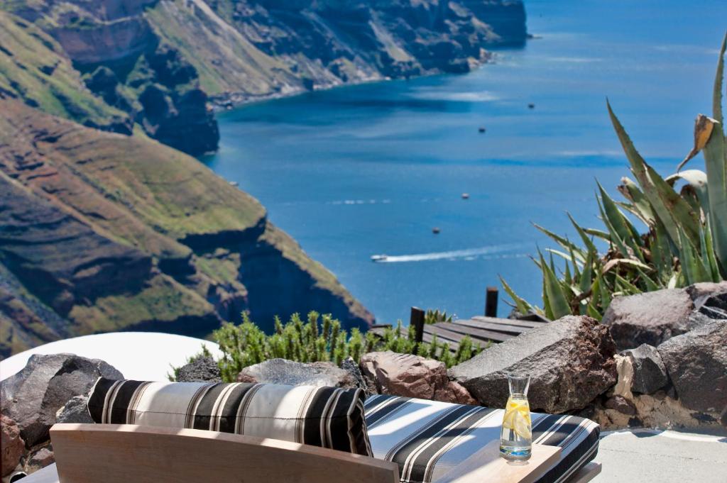 Skats uz klintīm un jūru no mājīga atpūtas vieta ar dīvānu un dzēriena glāzi. Daba un mierīga atmosfēra rada relaksējošu noskaņu.