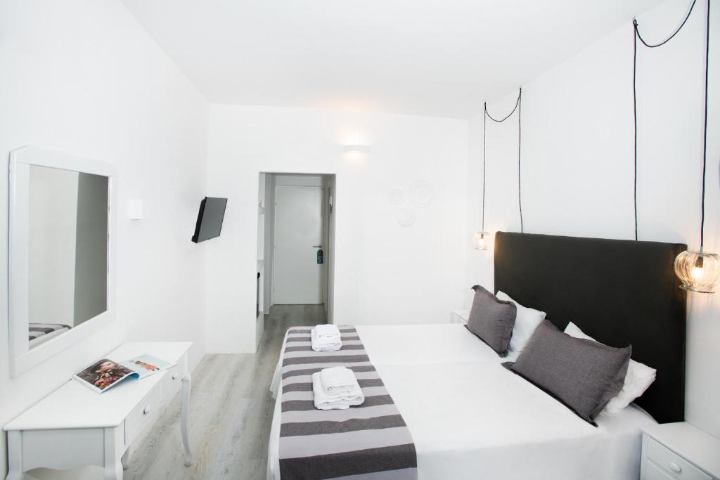 Mūsdienīgs un stilīgs viesnīcas numurs ar divām gultām, baltām sienām un modernām apgaismojuma ķermeņiem. Telpā ir spogulis un televizors, radot komfortablu atmosfēru.