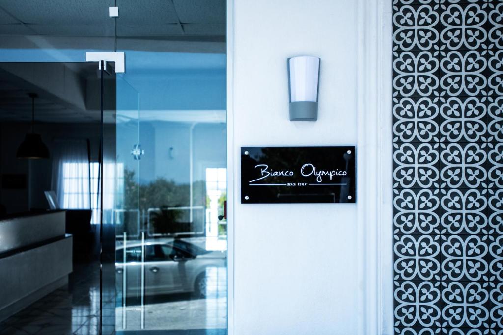 Bianco Olympico pludmales kūrorta ieeja ar modernu dizainu un dekoratīvu sienu.
