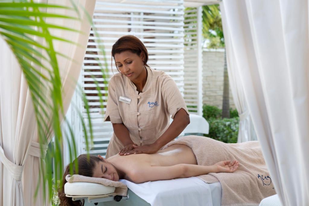 Masāža relaksējošā vidē, kur masāžas terapeits rūpīgi strādā ar klienta muguru.