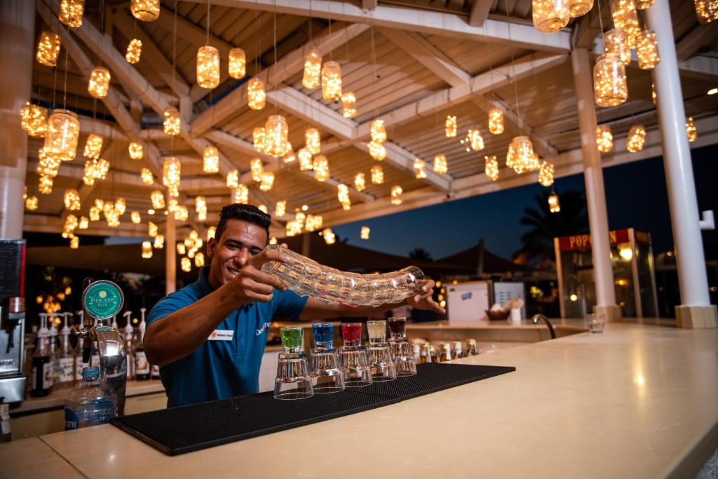 Bārmens Desert Rose Resort viesnīcā ar apgaismotu griestu dekoru.